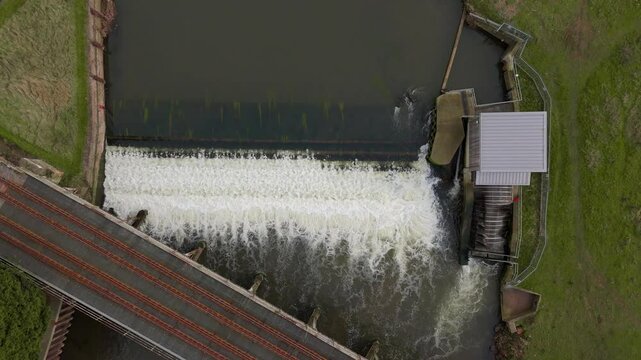 Aerial top down view exploratory barrier to fish on river Trent in England, UK weir dam hydropower fish pass migratory diadromous fish white water flowing 