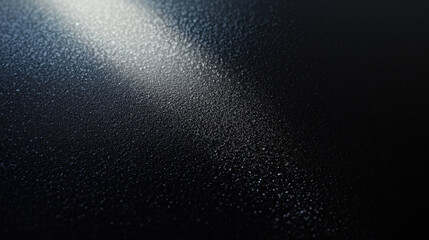 Obraz premium Dark background, black matte surface with a light beam on the right side, top view