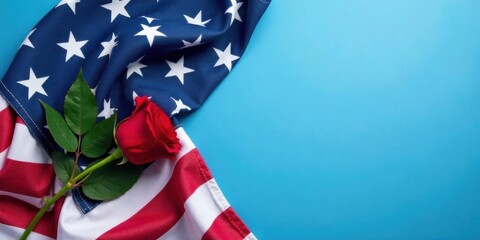 A single red rose rests gently on a folded American flag, against a vibrant blue backdrop, symbolizing remembrance and patriotism.