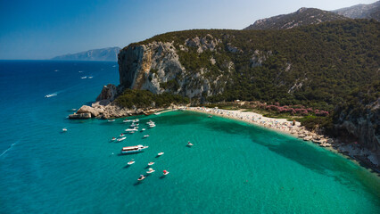 Amazing beach with perfect clear water and floating boats in Sardinia. 