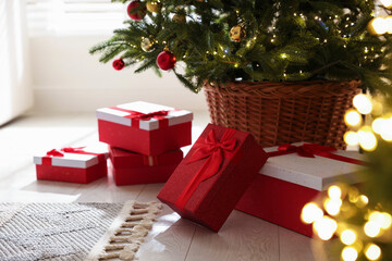 Gift boxes under Christmas tree in room. Bokeh effect