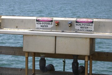red and blue turn handles on metal sink at beach