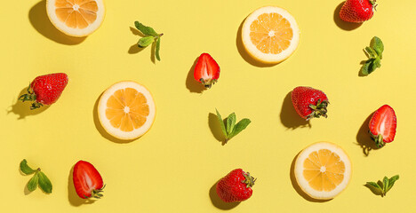 Fresh strawberries with lemon and mint on yellow background