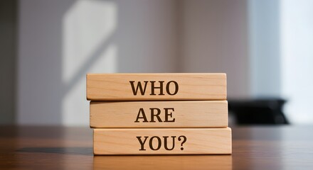 "Who are you? " question words on wooden blocks on blurred background.