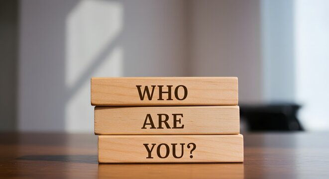 "Who are you? " question words on wooden blocks on blurred background.