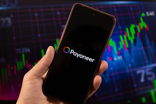 A smartphone with payoneer global payment service logo and blurred pyoneer interface at background