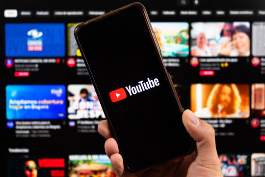 a smartphone with youtube logo and blurred youtube interface at background