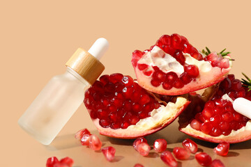 Bottle of essential oil and ripe pomegranate on color background