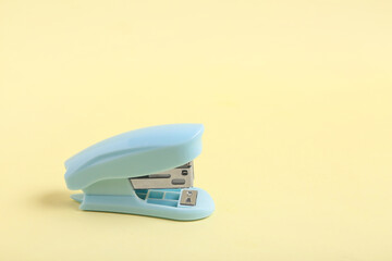 Blue stapler on yellow background