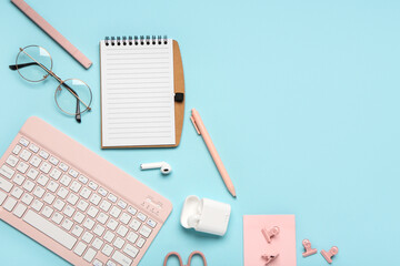 Composition with notebook, glasses and keyboard on blue background. Top view