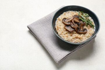 Tasty oatmeal with fried mushroom and arugula in bowl on white background