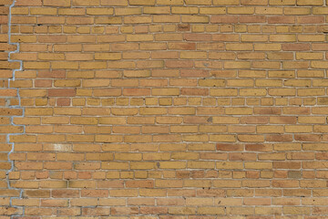Abstract texture background of a 19th century grungy urban brick wall surface, in a light brown...