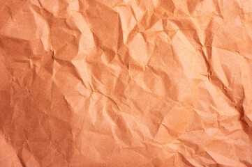 Fototapeta premium Full frame shot of crumpled orange colour paper sheet texture and background.