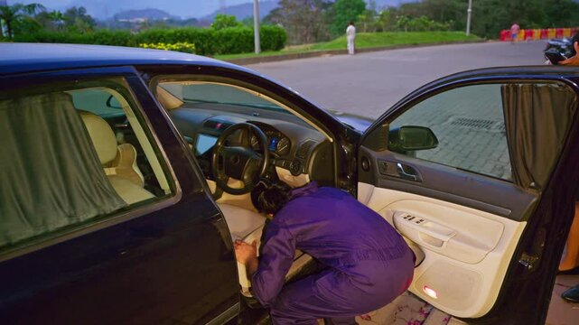 Bearded mechanic inspects broken down car outdoor
