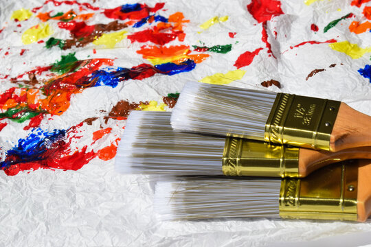 Stacked paintbrushes on a textured painted background