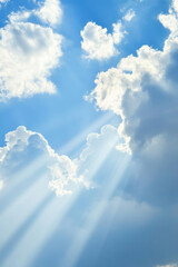 Bright blue sky with clouds and sun rays shining through