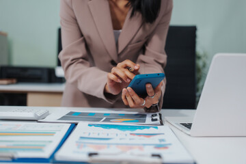 An Asian businesswoman accountant calculates invoices, taxes, interest, loans using a...