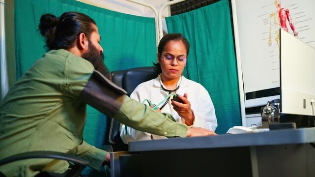 Female physician examines patient BP inside hospital