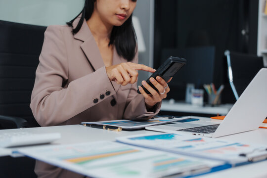 An Asian businesswoman accountant calculates invoices, taxes, interest, loans using a calculator,working online to guide clients through financial planning ensure a smooth loan process for success