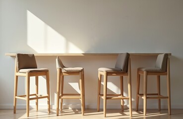 Four wooden bar stools stand against white wall under sun light. Minimalist interior features modern furnishing, wooden design. Contemporary furniture offers simple, elegant seating at counter height.