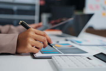 An Asian businesswoman accountant calculates invoices, taxes, interest, loans using a...