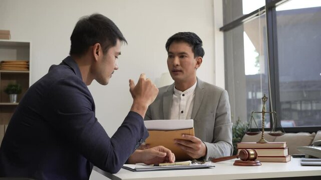Two Asian businessmen meet at the table with wind power engineers to discuss renewable energy solutions. They exchange ideas on wind turbines, solar energy,simulations for sustainable development