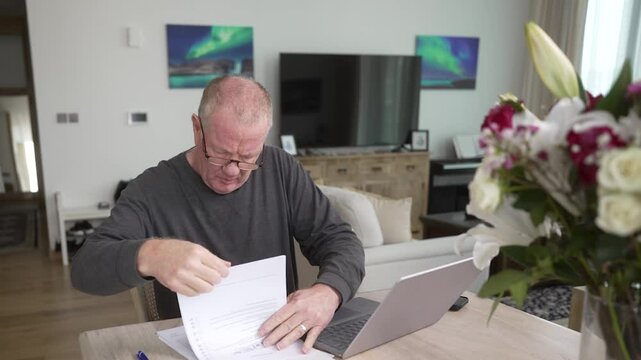 Older man frustrated with confusing tax forms and how to use computer software apps