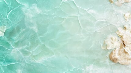 Fototapeta premium Aerial view of turquoise sea waves gently blending with white sandy shore, creating a tranquil natural landscape.