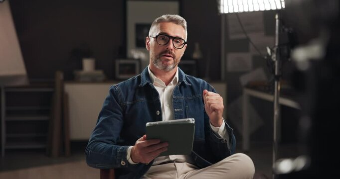 Tablet, broadcast and live streaming with man in studio for social media, content creation and vlogger. Subscription channel, virtual interview and talking with person and recording for audience