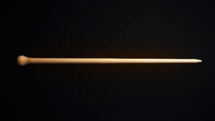 A wooden baton conductor against a dark background