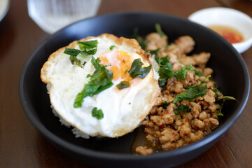 delicious Thai dish featuring stir fried minced pork with basil and fried egg served over rice, showcasing vibrant colors and textures