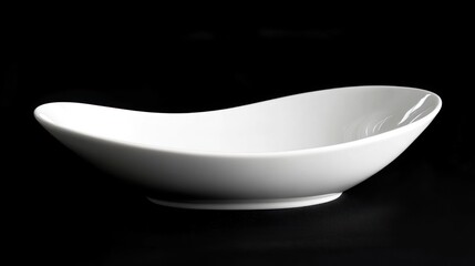Empty white ceramic oval dish on black background.