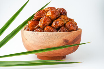 Dates fruit sukari or kurma sukari, in wooden bowl isolated on white background