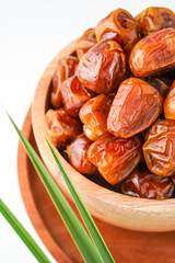 Dates fruit sukari or kurma sukari, in wooden bowl isolated on white background