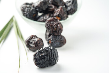 Dates fruit ajwa or kurma ajwa, in bowl isolated on white background