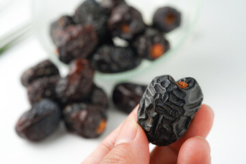 Dates fruit ajwa or kurma ajwa, in hand isolated on white background