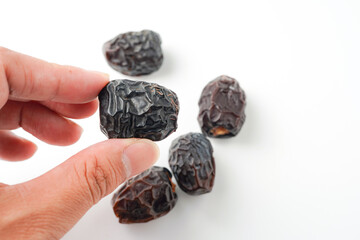 Dates fruit ajwa or kurma ajwa, in hand isolated on white background