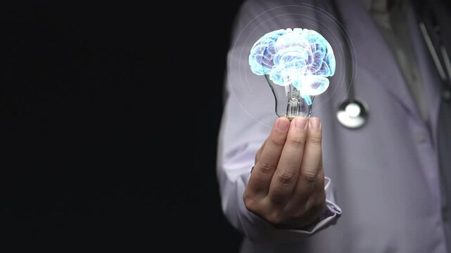 Close up of doctor picking and holding light bulb with human brain anatomy hologram floating. Smart medical worker representing brain structure and accessing neuroscience. Technology design. Remedial.
