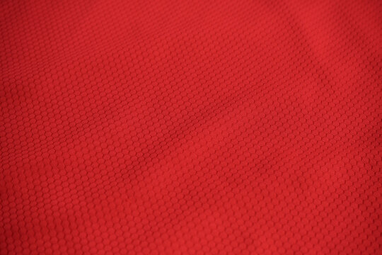 Texture of red jersey clothing fabric. Flatlay style, close up, studio shot. Sport background. Fabric commonly used for sportswear as football, basketball, volleyball, hockey, rugby etc
