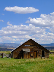 A decrepit beautiful wooden barn under the clouds of Northern California's Warner Mountains