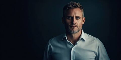 Fototapeta premium Confident Man in a Button-Up Shirt Against a Dark Background