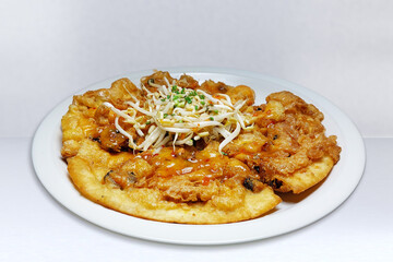 Crispy fried mussels with a spicy dipping sauce served on a white ceramic plate is a delicious Thai street food. and gained popularity.