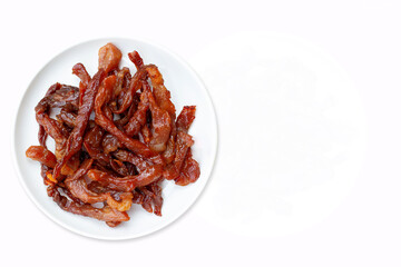 Fried dried pork on a white round plate on a white background. Top view.
