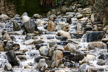 Artificial waterfall for park or garden decoration. An artificial waterfall that provides coolness in the summer months and where animals can drink water. 