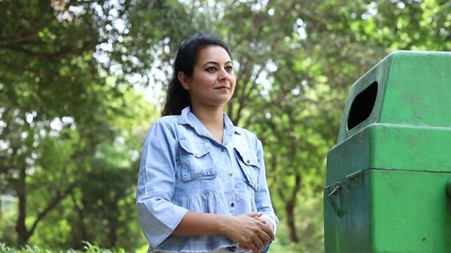 Indian woman throw empty litter in recycling bin, Asian female drop plastic bottle into garbage bin, pollution or waste management and save environment concept.