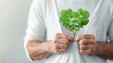 person in white shirt holds green plant shaped like heart, symbolizing love for nature and environmental care. image conveys message of sustainability and connection with earth