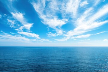Obraz premium Vast ocean under a blue sky with wispy clouds. Perfect for travel, serenity, or nature themes.