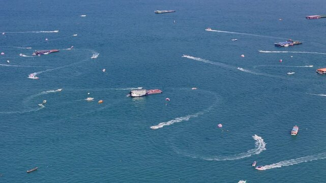 Drone shot of boats and yachts moving across blue sea water surface