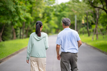 Back, Young Asian woman jogging with her father at park with smile. Healthy woman and senior man do...