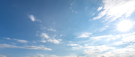 Obraz premium Clear blue sky with a few clouds and a sun shining brightly